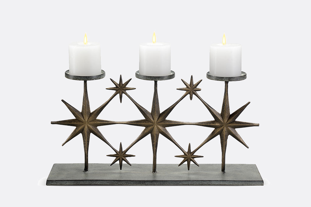 metal candleholder with large star motifs holding three candles