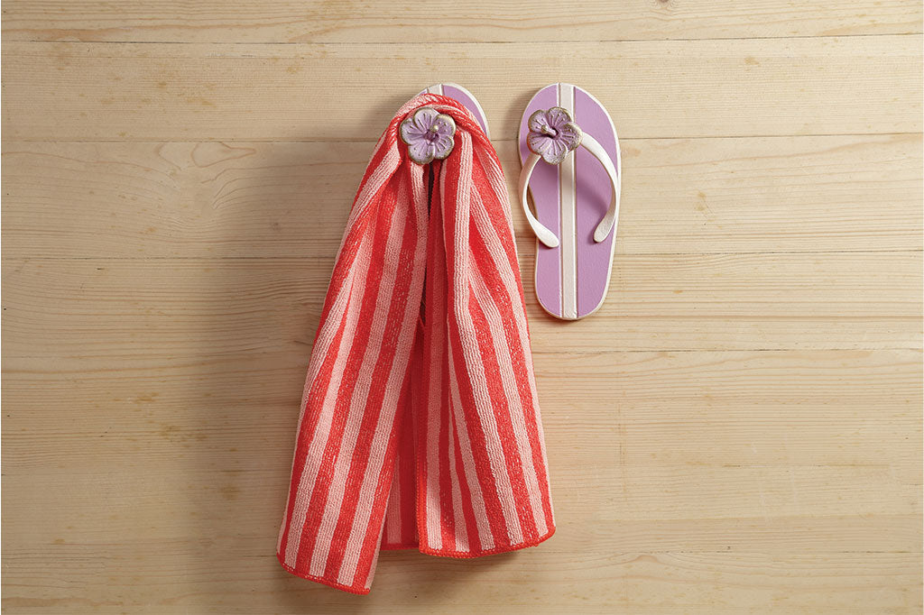 Pink flip flip wall hook with red stripped towel handing down #color_plum
