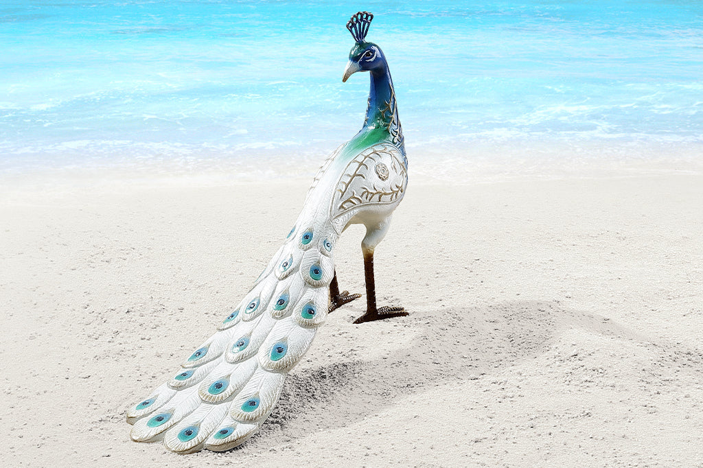 white and blue peacock sculpture shown on beach