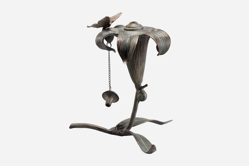outdoor footed oil torch in sculpted lily and butterfly motif with accent snail