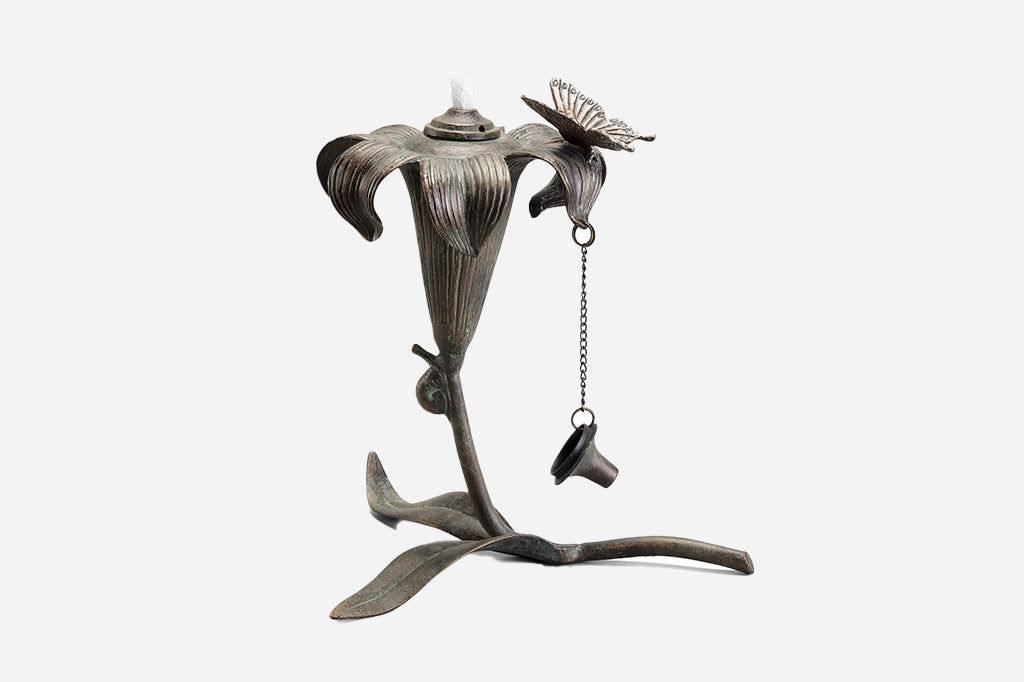 outdoor footed oil torch in sculpted lily and butterfly motif with accent snail