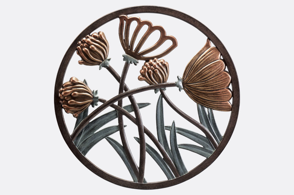 Cast metal circular wall plaque of thistle and blossom