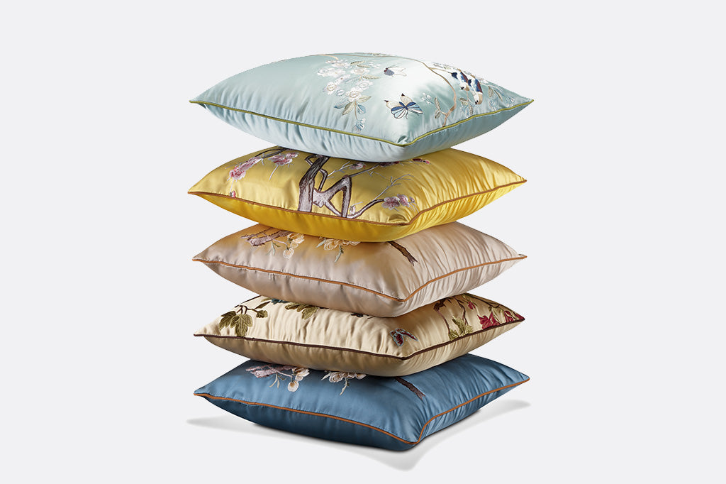 stack of five satin pillows against gray background