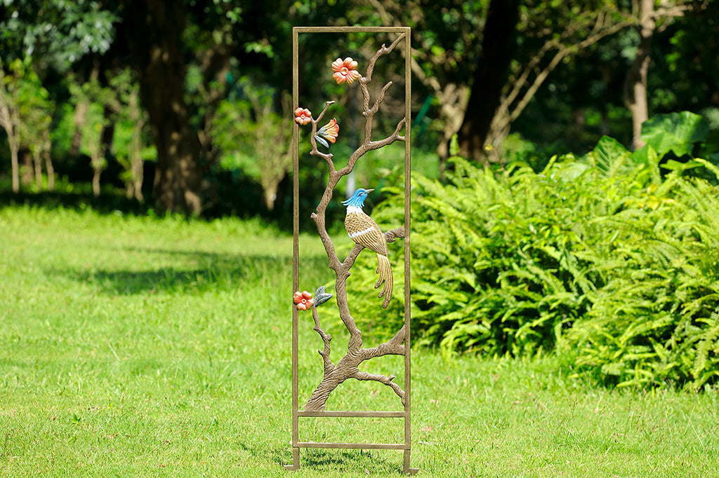 tall garden trellis with bird branch and blossom details against garden background 