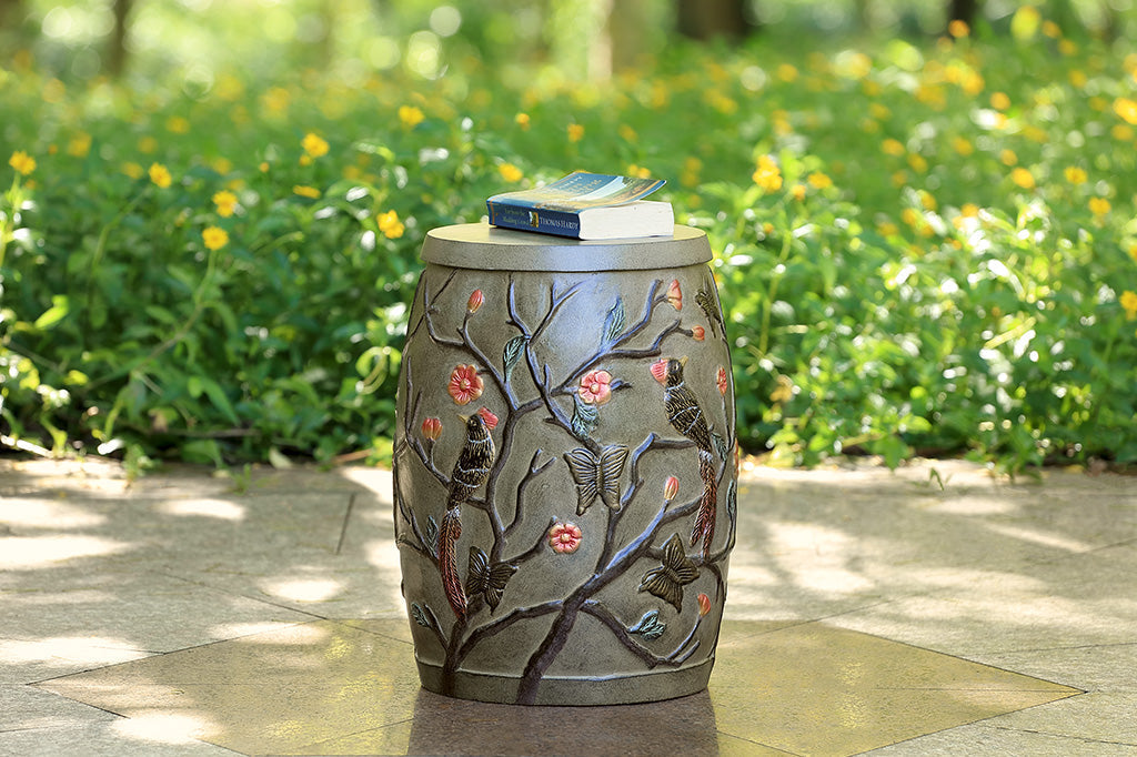 Chinoiserie style garden stool with removable lid shown outside with book in peaceful garden