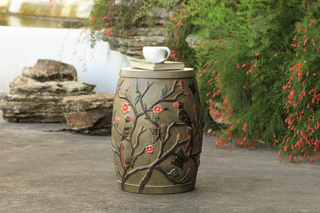 Chinoiserie style garden stool with removable lid shown outside with book and teacup in peaceful garden