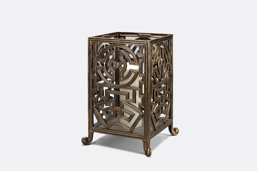 bronze rectangle lantern with white candle inside against gray background