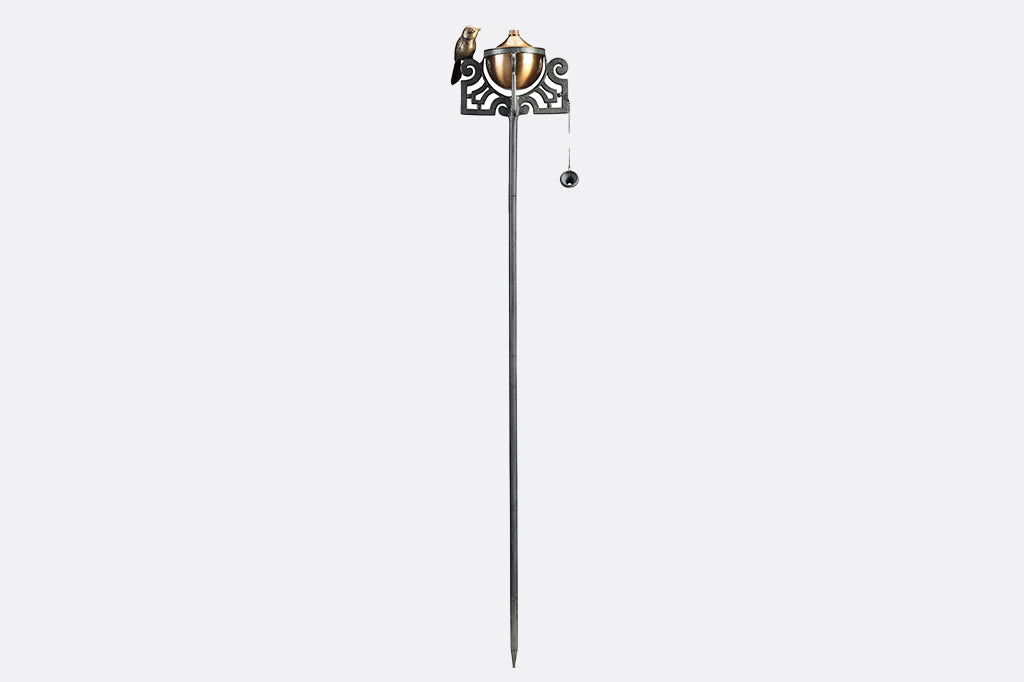 Mission style motif of scrollwork and bird on a garden oil torch