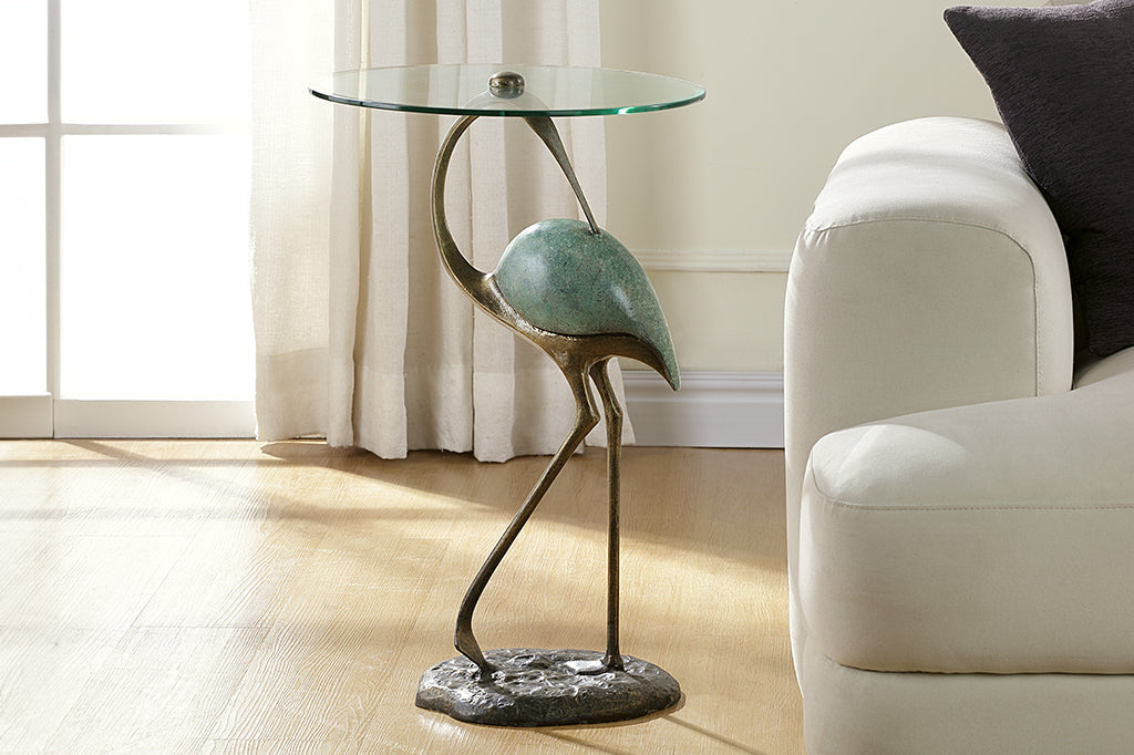 Elegant crane sculpture is the base for a drink table with glass top