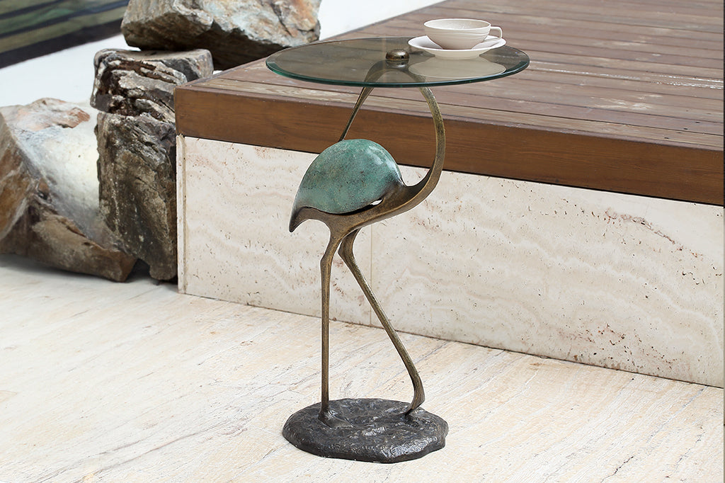 Elegant crane sculpture is the base for a drink table with glass top - shown in rock garden with teacup
