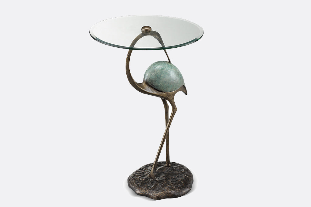Elegant crane sculpture is the base for a drink table with glass top