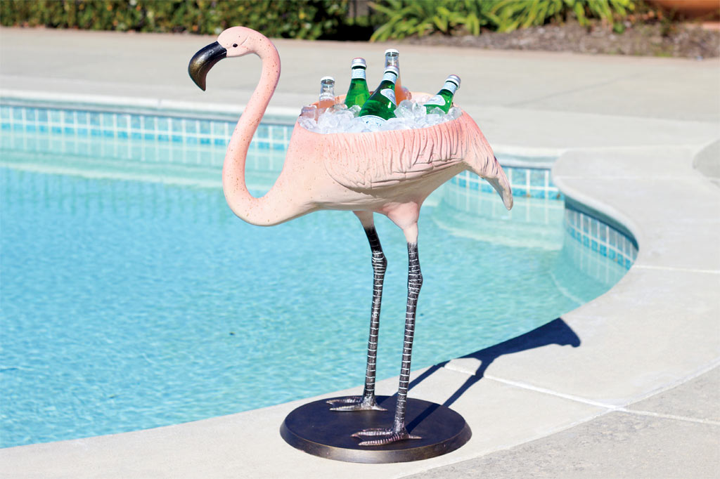 cast metal flamingo sculpture has wide basin in its back for holding ice and beverages; shown poolside outside on sunny day