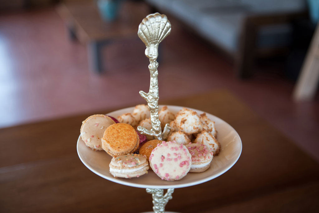 Pacifica Plate Stand shown with macarons on top ceramic plate, closeup detail on shell finial