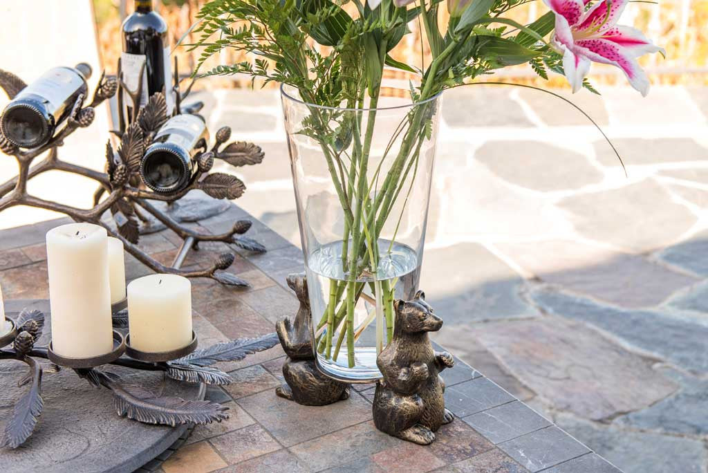Vase of lilies shown outside on slate table holding lodge-themed serveware