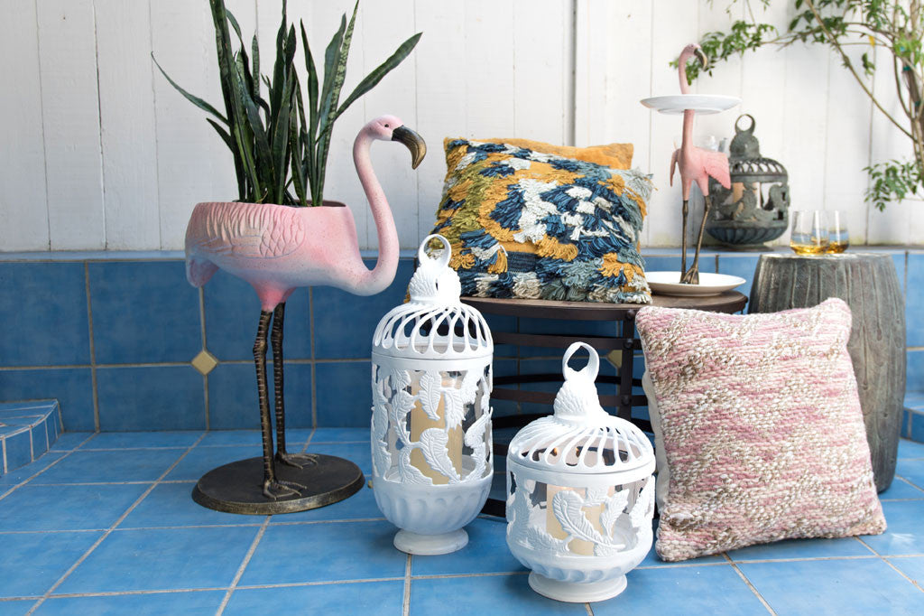 Festive Flamingo Planter & Beverage Tub shown in tiled patio area with pillows and lanterns; it holds a snakeplant