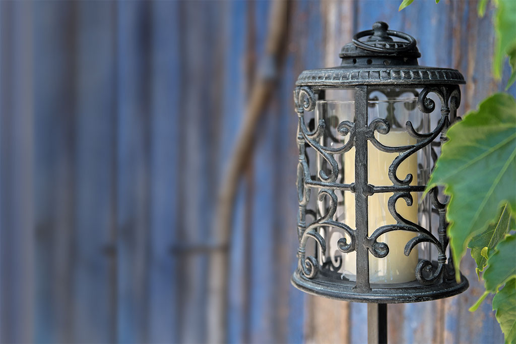 close up view of cylindrical candle stand: Rouleau Tall Garden Lantern shows elegant filagree scrollwork
