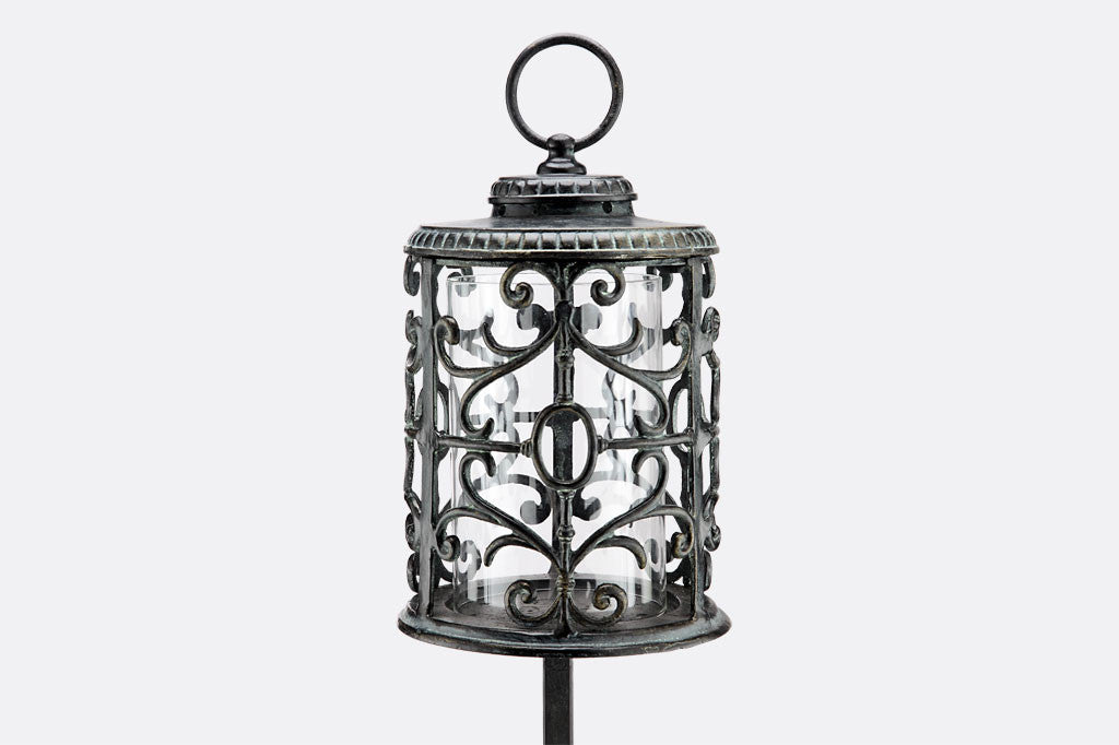 Rouleau Tall Garden Lantern shows elegant filagree scrollwork on cylindrical candle surround - pole garden lighting with base