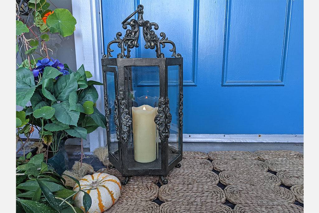 Rouleau Six Pane Lantern on a doorstep near plants and a blue door