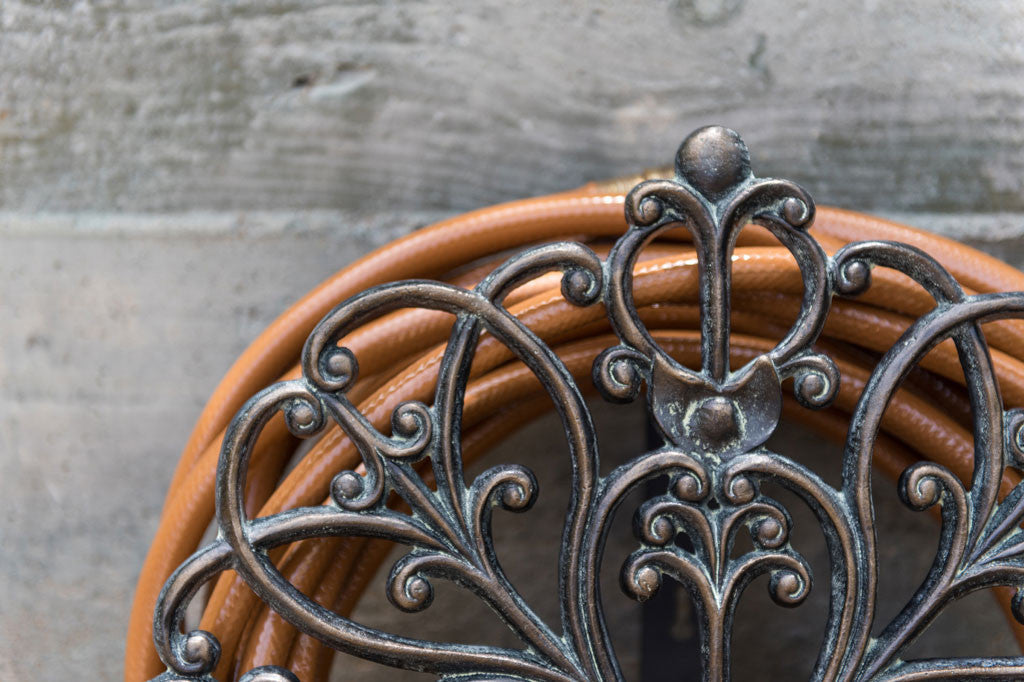 Rouleau Hose Holder Silhouette - features scrollwork in zinc colors on a wall mount to hold garden hose