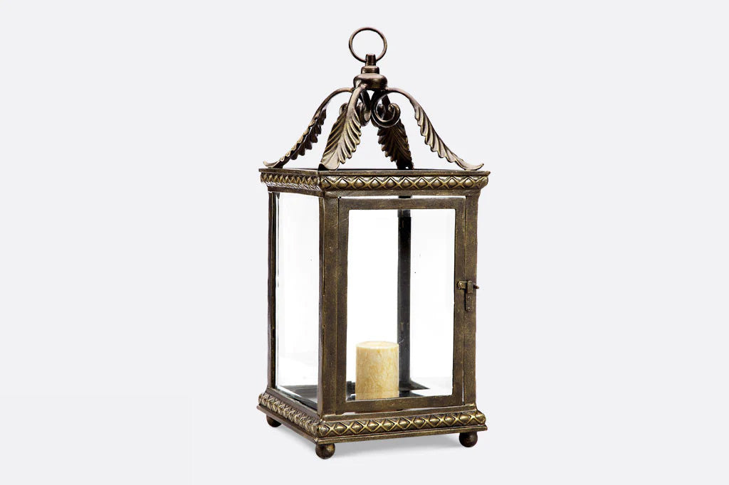 Foglia lantern features acanthus leaf corner accent, shown with cream candle