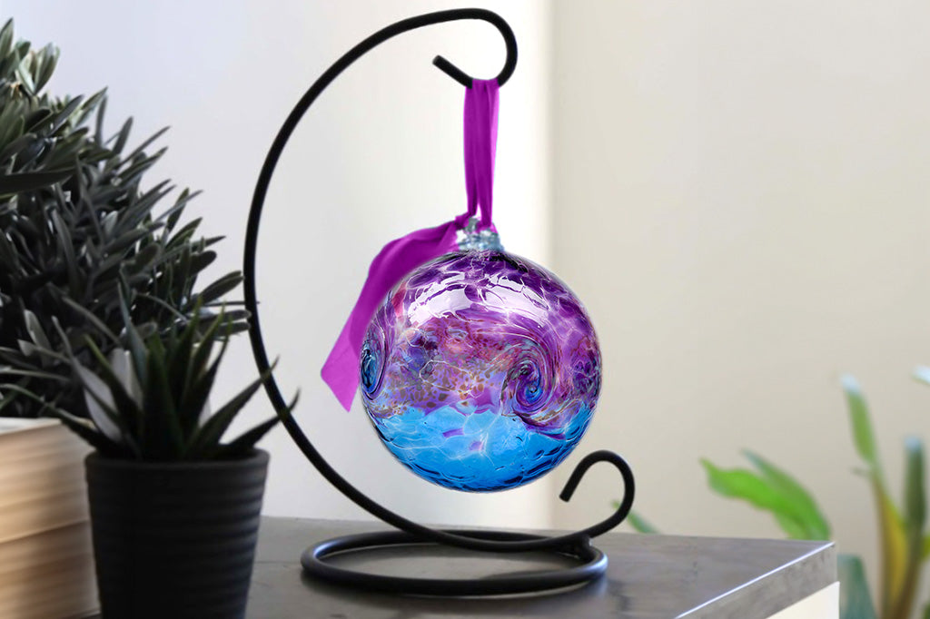 Handblown glass ornament designed to hang from metal stand