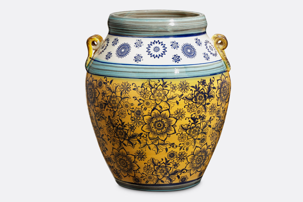 Handmade ceramic pot with floral print, yellow base with navy flower print. white and light blue detailing. Urn shaped with two handles on side