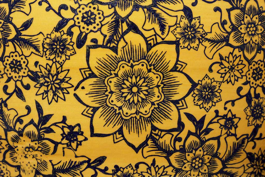 Close up of floral print, golden yellow base with navy floral print