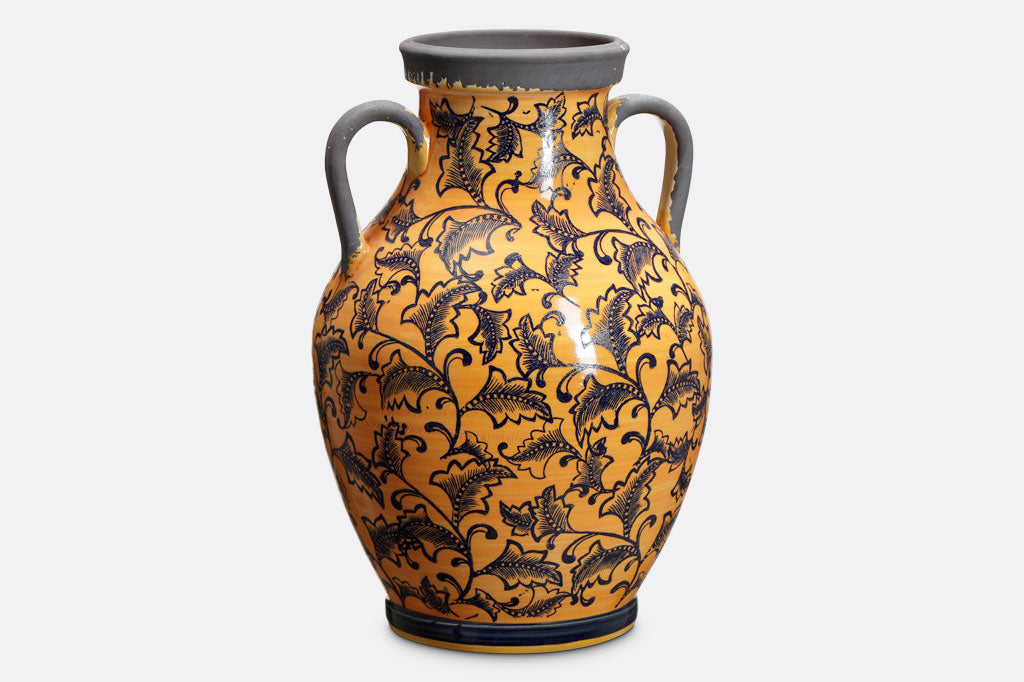 Orange-Yellow vase covered in dark leaf Mediterranean style print with two classic handles in grey that matches the rim.
