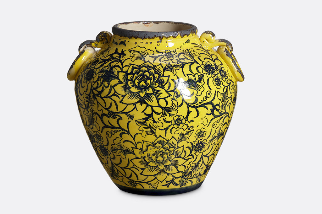 Pera Pot features bright yellow ceramic glaze with dark stamped motif of flowers and vines; two faux stylized ring handles