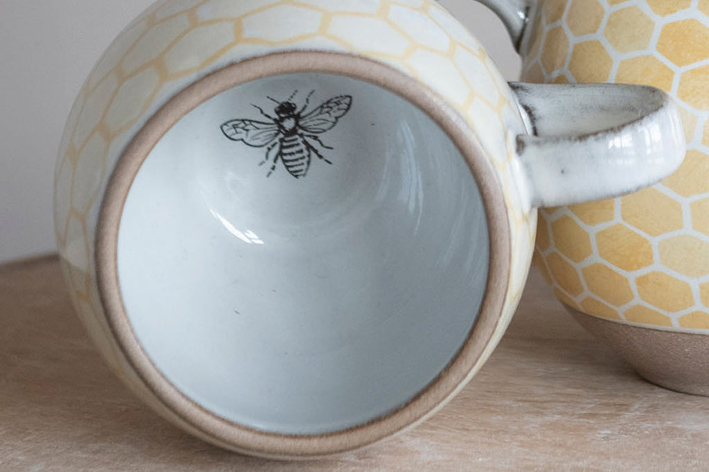 stoneware mug with honeycomb design and bee illustration interior