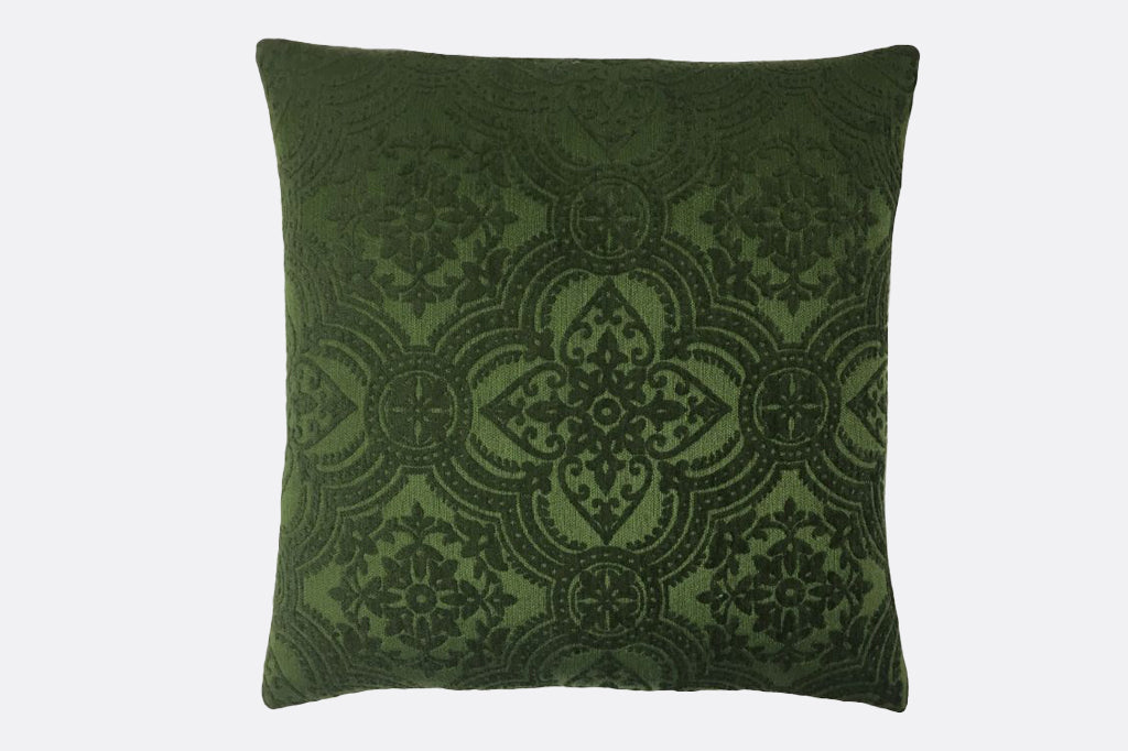 green embossed velveteen throw pillow with pattern like floral fretwork