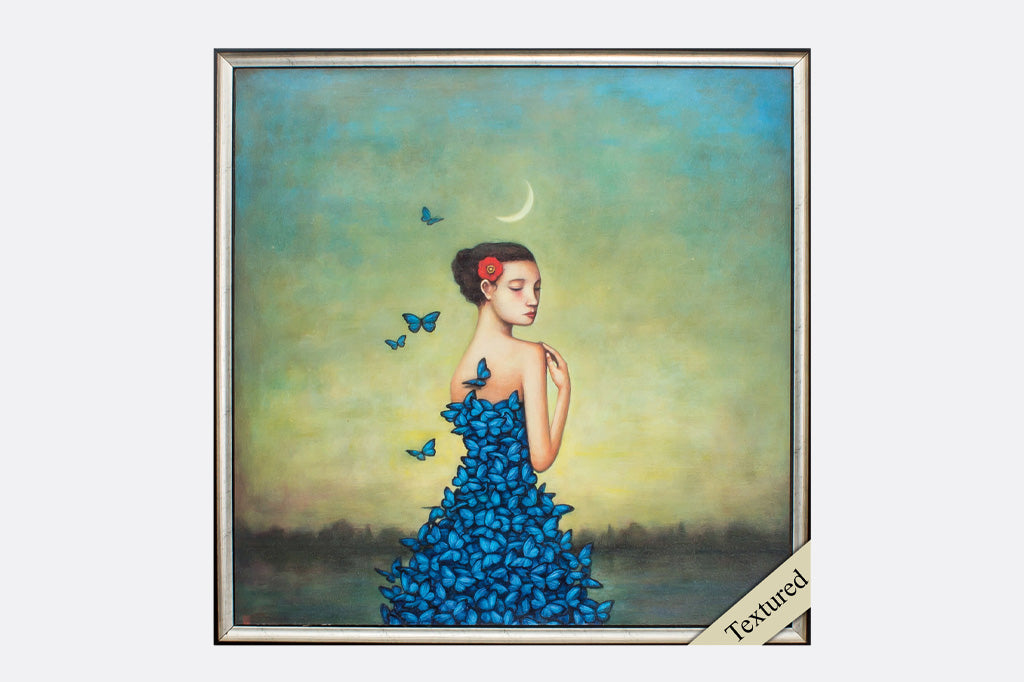 framed art print of woman wearing blue dress made of butterflies standing under crescent moon