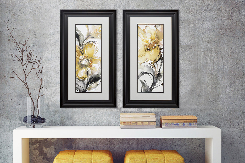 black framed art with yellow impressionist style flowers, vertical style shown above modern desk with yellow stools