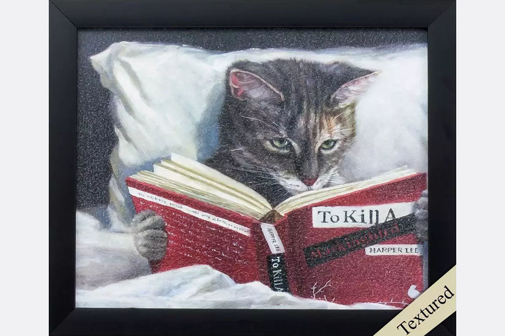 Framed art of cat reading To Kill a Mockingbird in bed