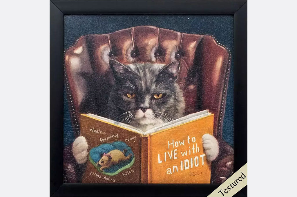 framed art: print of cat reading a book called How to Live with an Idiot