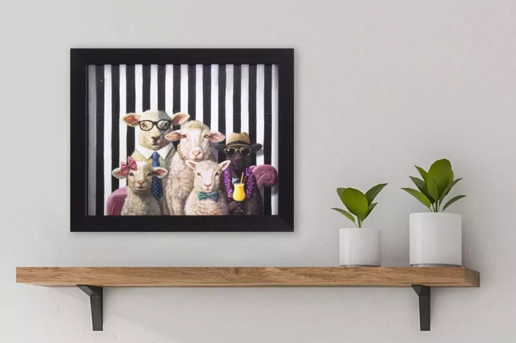 framed art of sheep family in human clothing shown above home wall shelf
