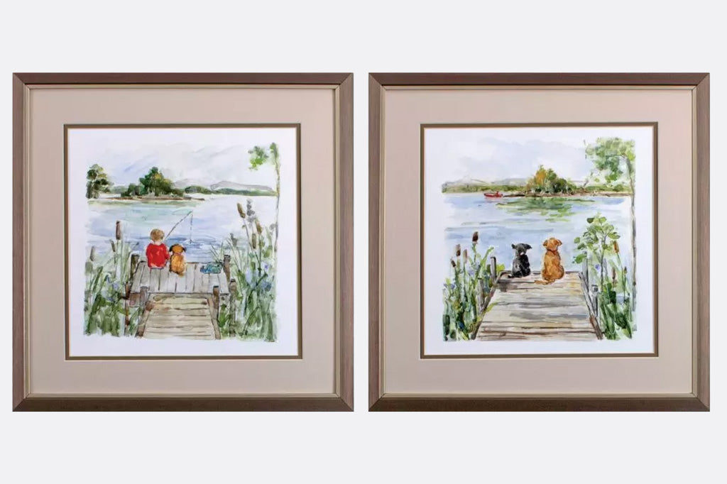 two framed art pieces on wall, boy and dog fishing on dock and two dogs sitting on sock over looking lake