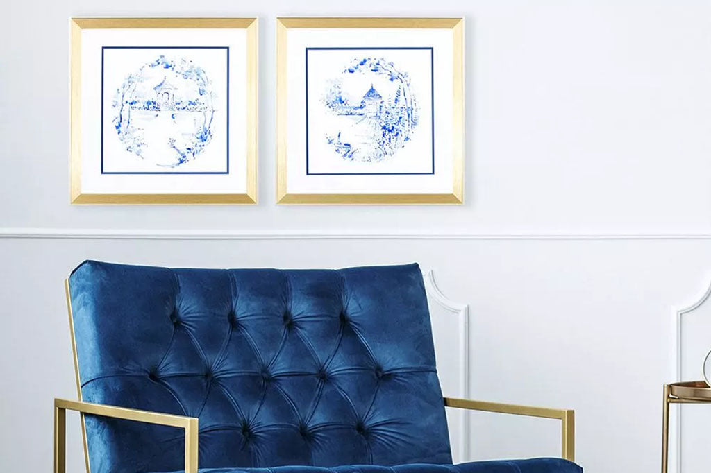 Delft-style white and blue framed art print set shown above blue couch