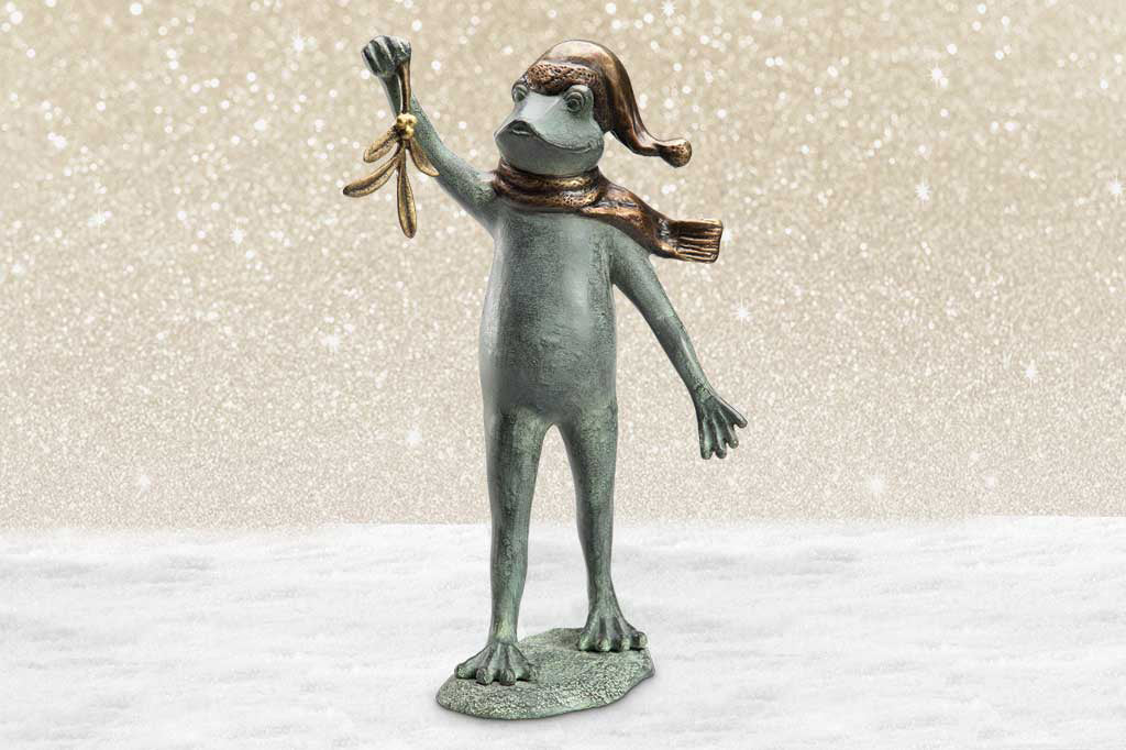 garden sculpture of frog in winter garb holding mistletoe from outstretched webbed hand