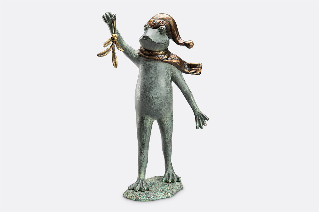 garden sculpture of frog in winter garb holding mistletoe from outstretched webbed hand