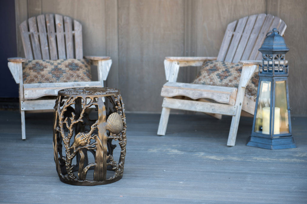 Under The Sea Garden Stool in bronze finish shown on beach house deck. two adirondak chairs are placed in background by a large garden lantern with lighthouse design.
#color_bronze