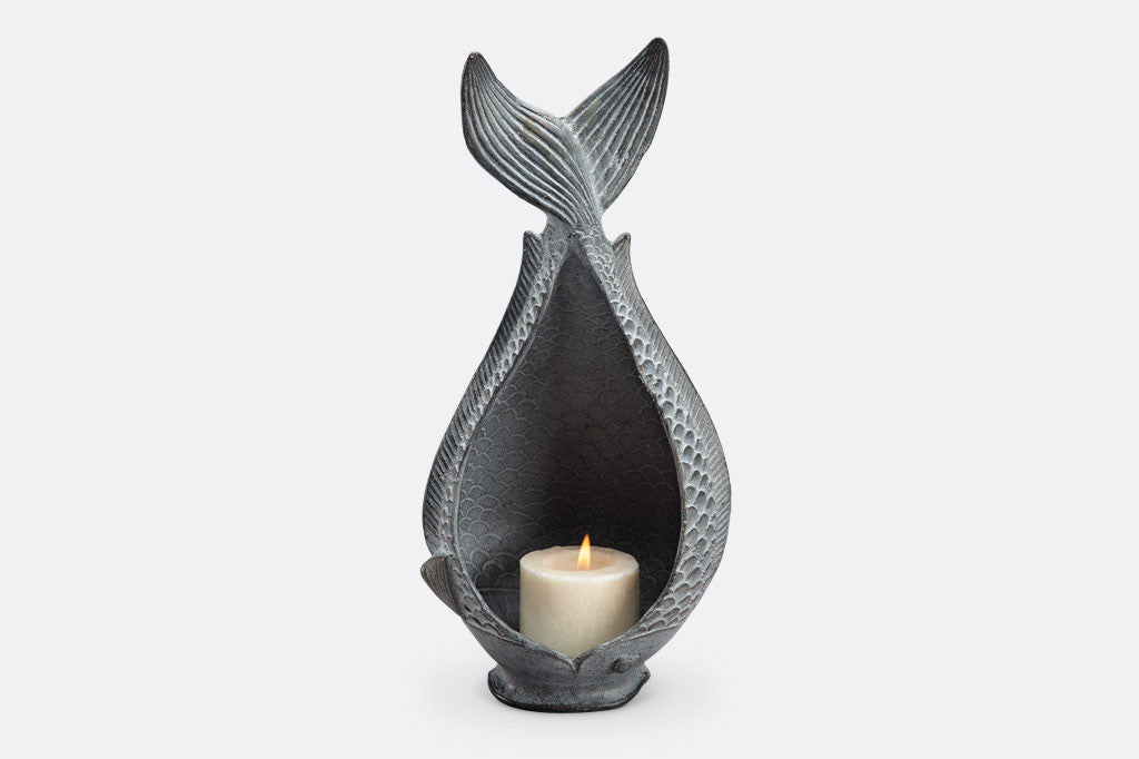 Diving Fish Candleholder shown with lit candle; fish shaped vessel with tail up in zinc