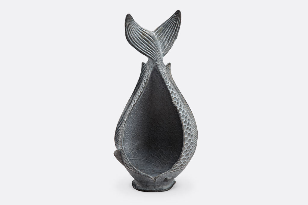 Diving Fish Candleholder shown with lit candle; fish shaped vessel with tail up, in zinc finish, embty inside