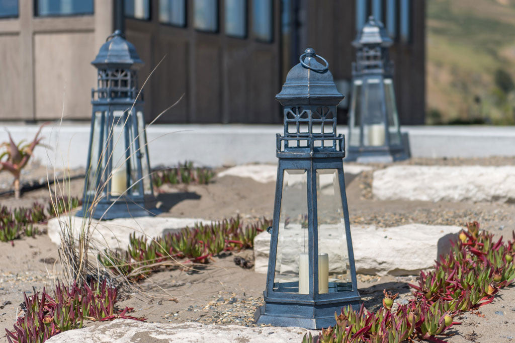 Lighthouse Lantern shown on the beach near a beach house