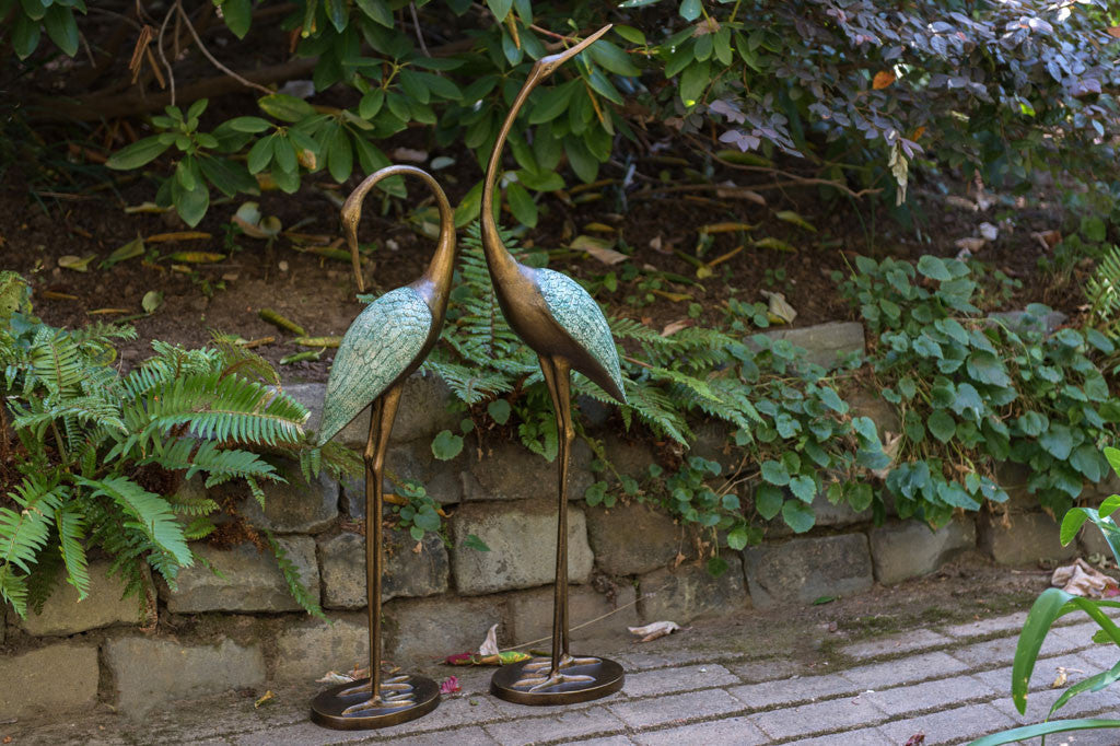 cast metal pair of cranes with blue detailing on feathers