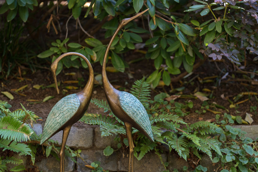 cast metal pair of cranes with blue detailing on feathers