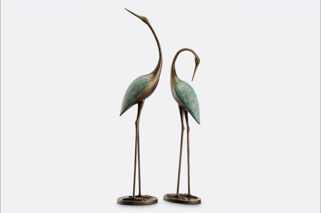 cast metal pair of cranes with blue detailing on feathers