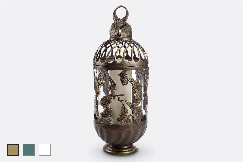 Tall cast metal bronze swirling feather lantern with lit pillar candle inside
#color_bronze
