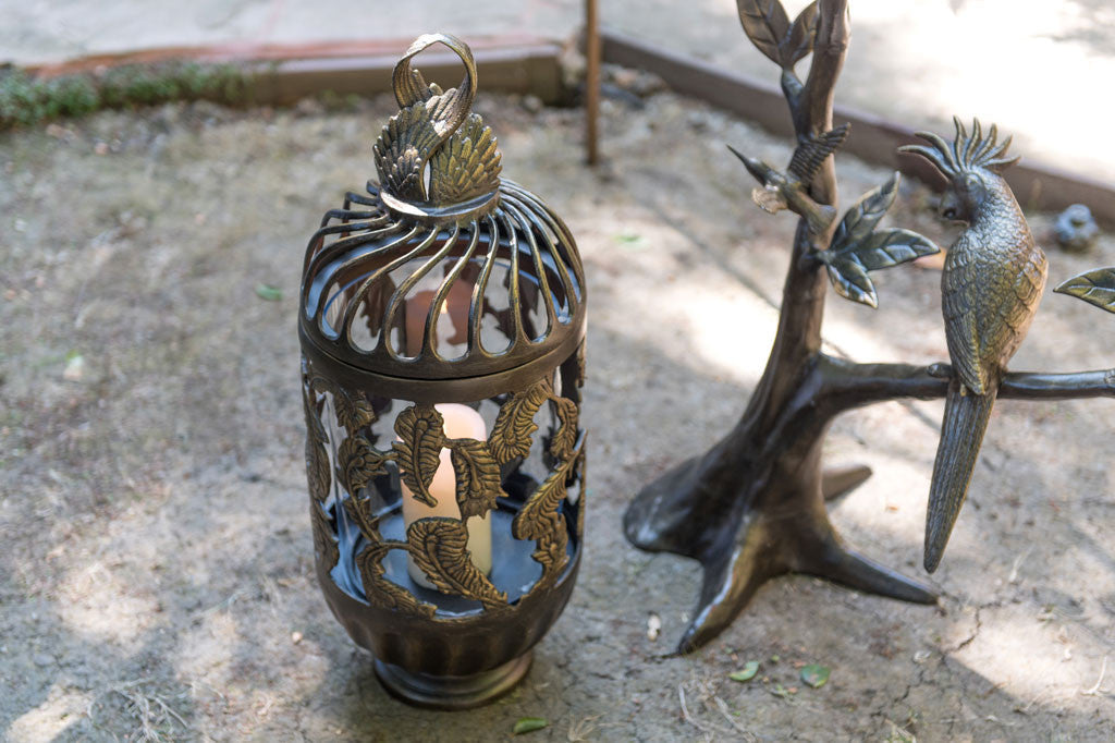 bronze cast metal swirling lantern with pillar candle inside
#color_bronze