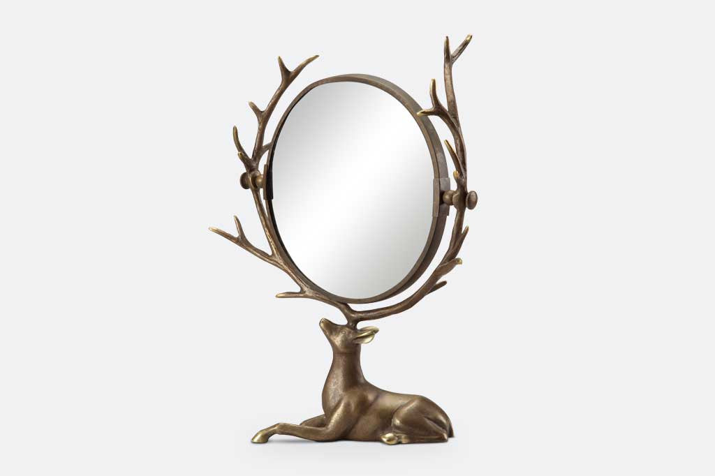 vanity mirror supported by resting deer whose antlers frame the mirror
